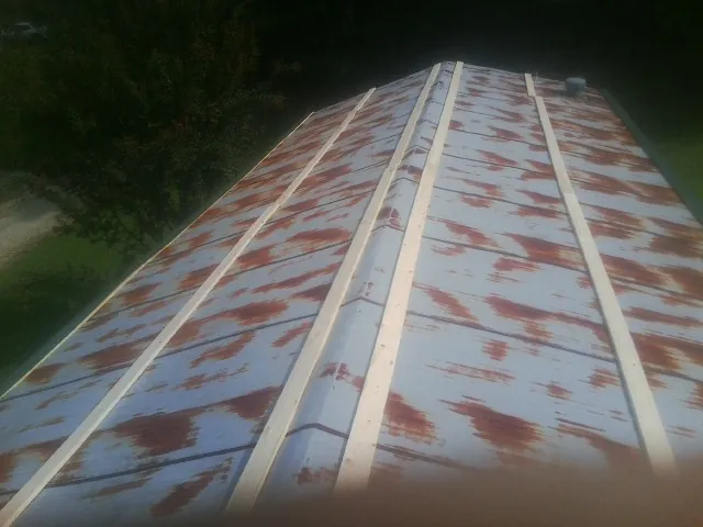 Rusted metal roof panels with new wood purlins before replacement — Storm Damage Roof Repair in Kingsport by Roofing Brothers