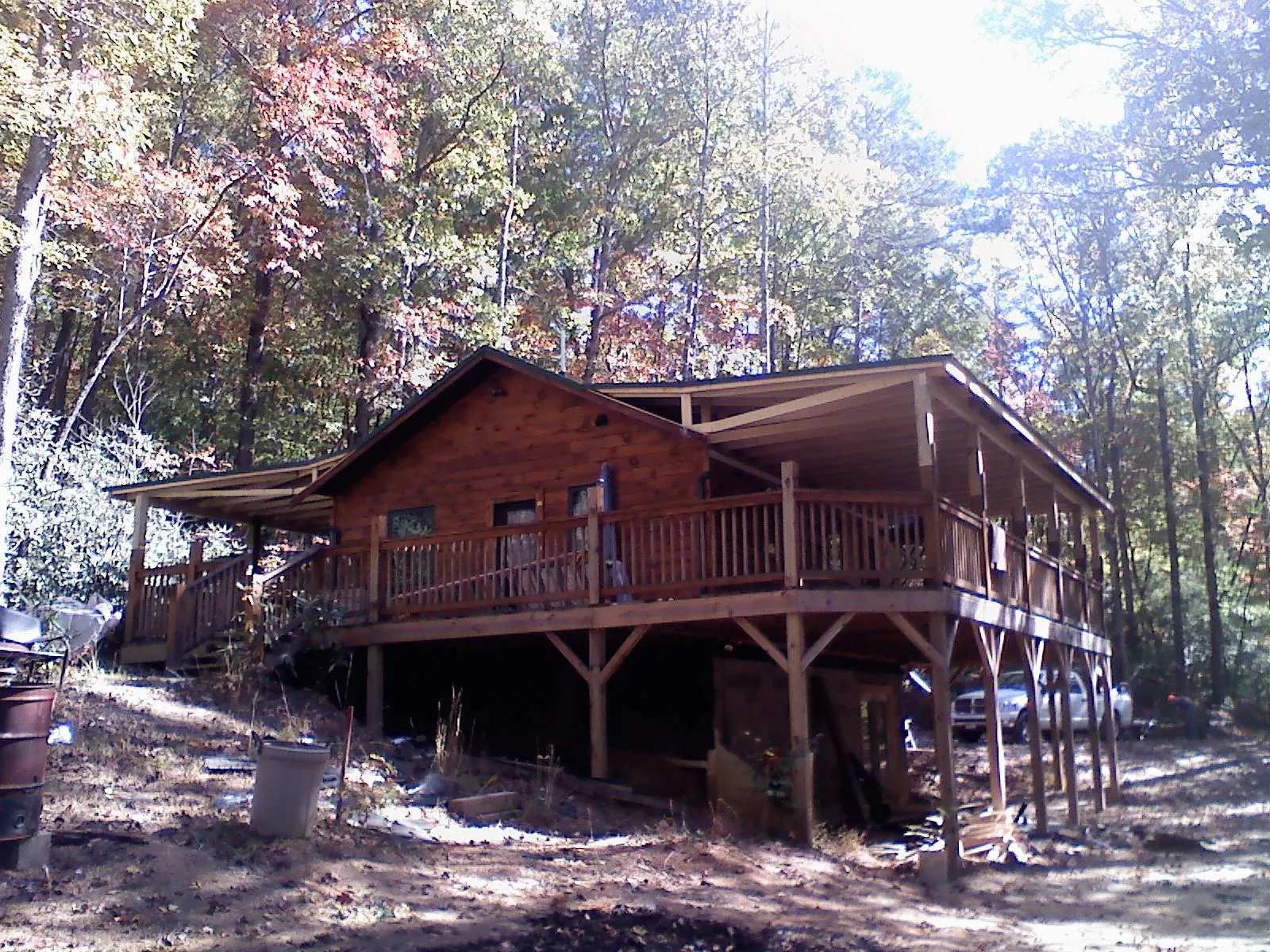 Log cabin with a wraparound porch and metal roof in the fall in Kingsport