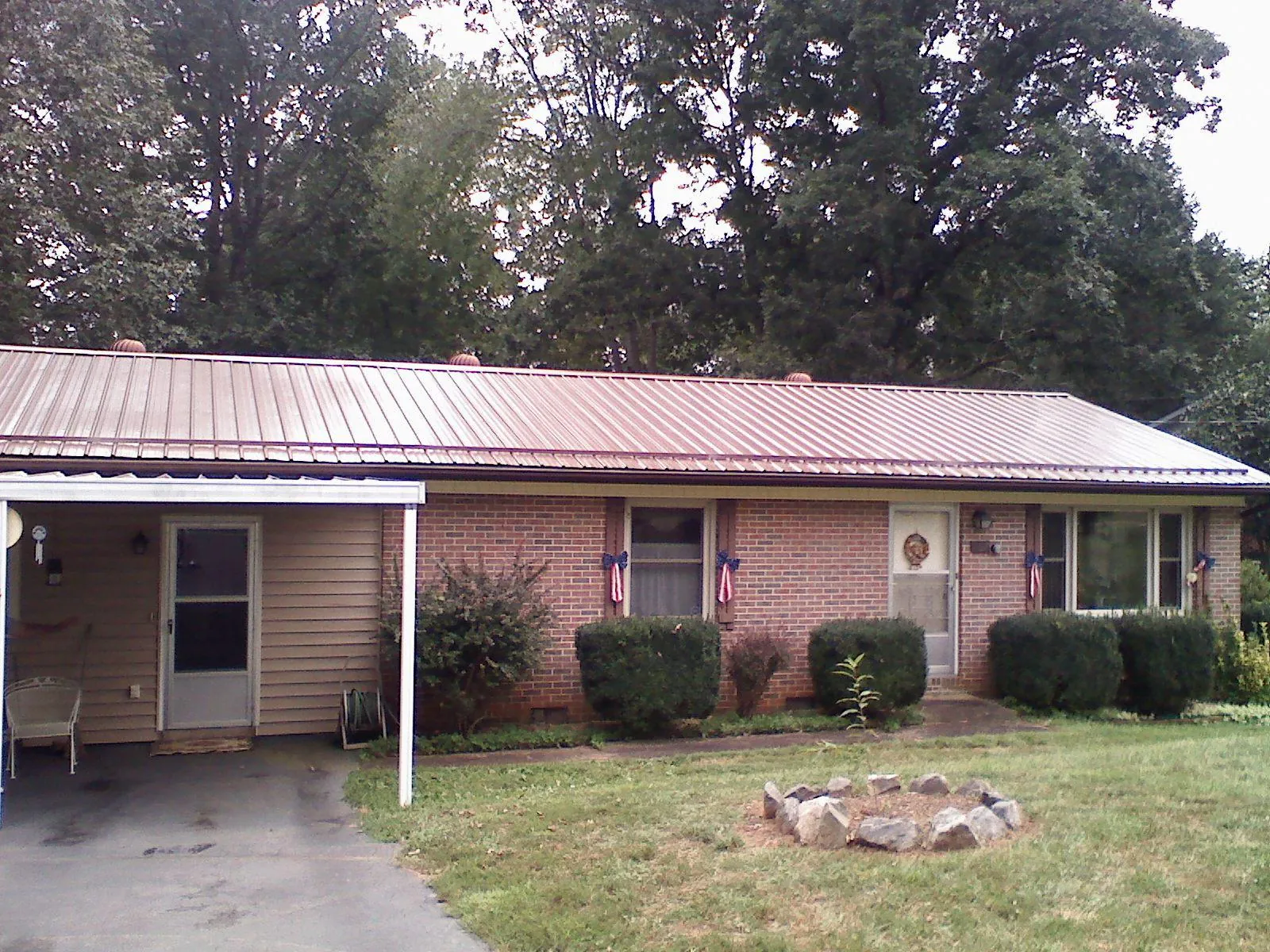 Bronze metal roof and carport on a brick ranch home — Roof Repair work by our crew in Kingsport